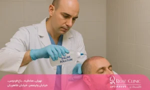 دکتر با دستکش و روپوش سفید در حال شستشوی سر بیمار با سرم شستشو پس از کاشت مو.